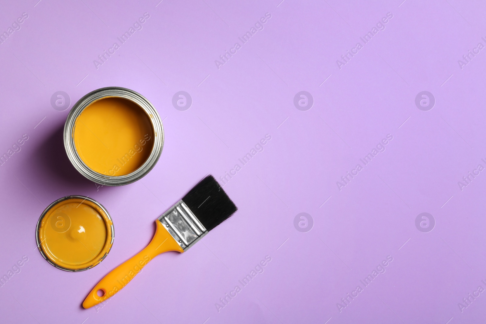 Photo of Open paint can, brush and space for text on color background, top view