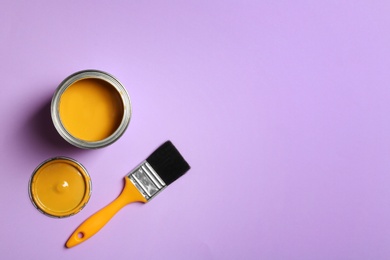 Photo of Open paint can, brush and space for text on color background, top view