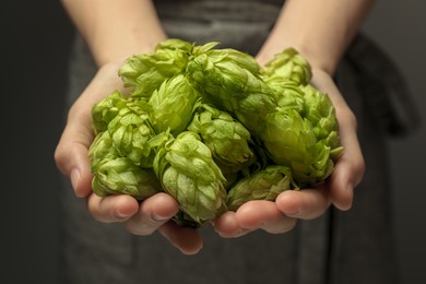 Photo of Woman holding pile of fresh ripe hops, closeup