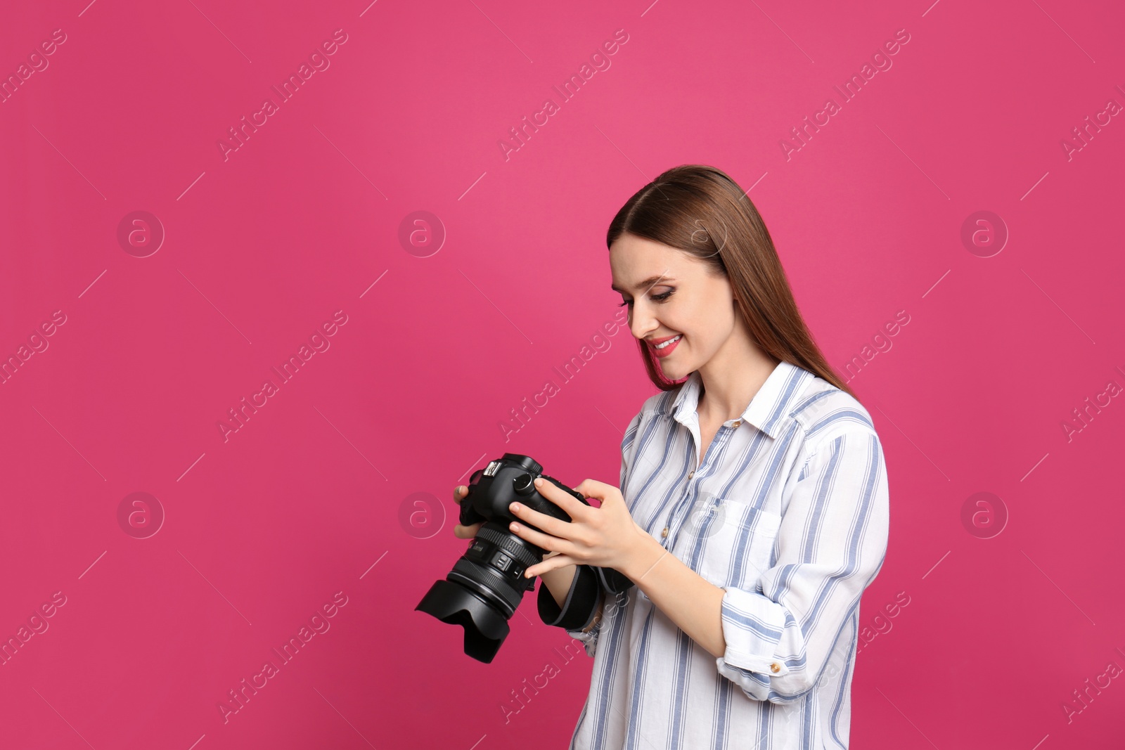 Photo of Professional photographer with modern camera on pink background