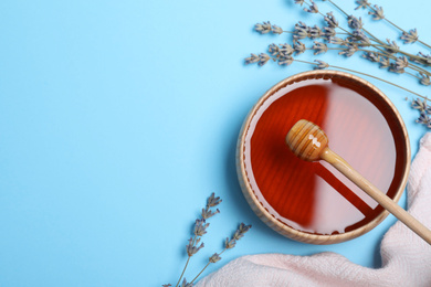 Flat lay composition with organic honey on light blue background. Space for text