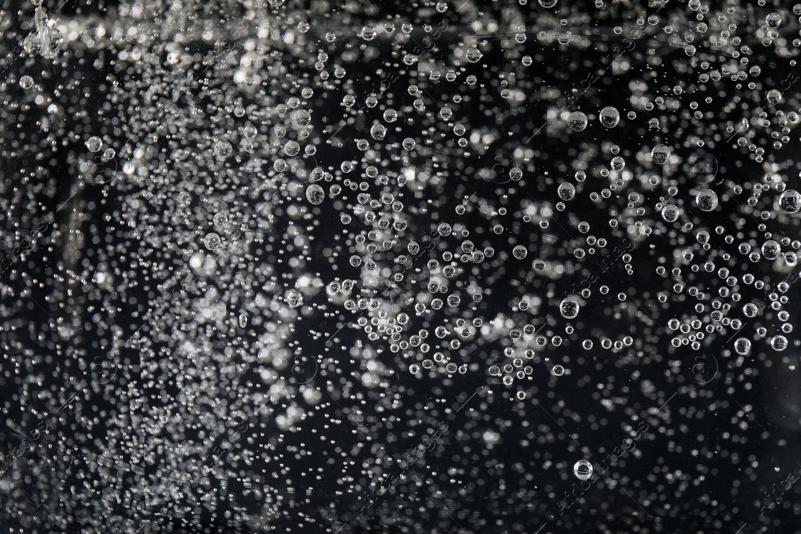 Photo of Clear soda water against black background, closeup