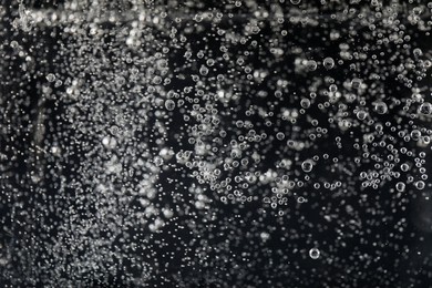 Photo of Clear soda water against black background, closeup