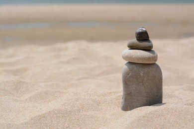 Photo of Stack of stones on beautiful sandy beach, space for text