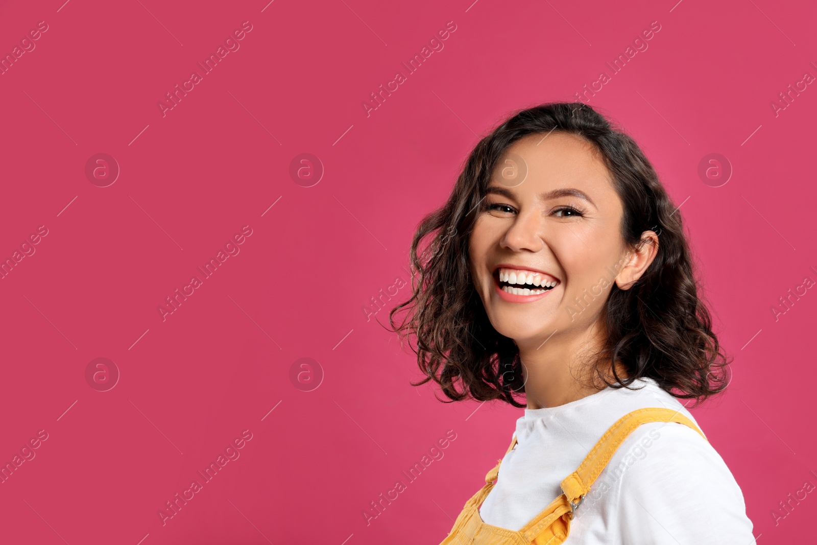 Photo of Happy young woman in casual outfit on pink background. Space for text