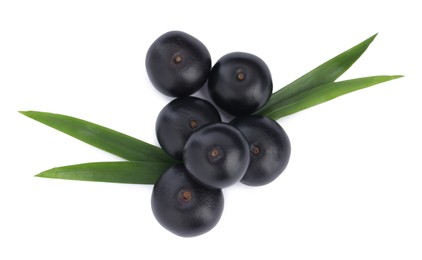 Photo of Pile of fresh ripe acai berries and green leaves on white background, top view