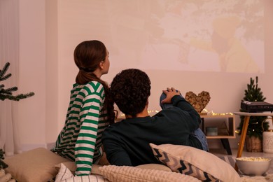 Couple watching movie via video projector at home