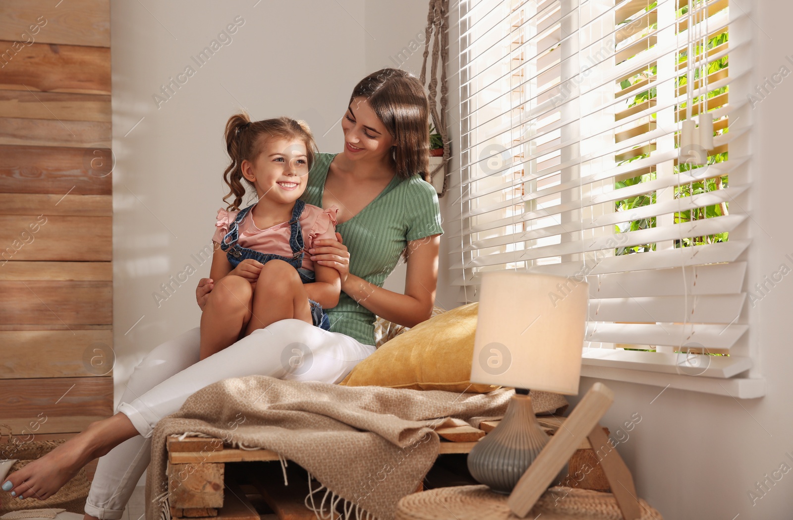 Photo of Happy mother with little daughter near window at home