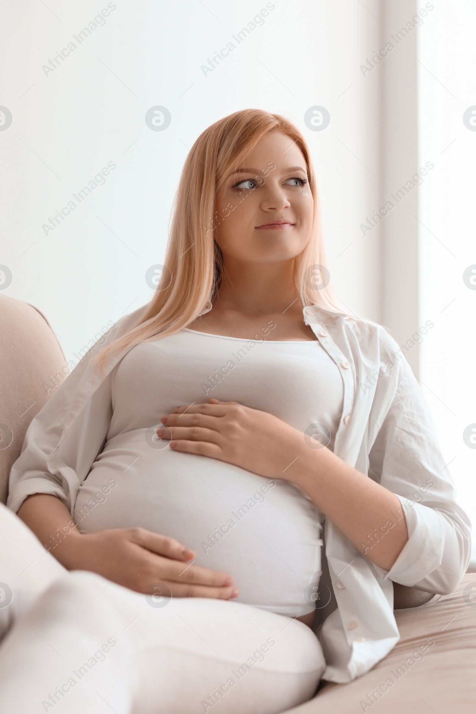 Photo of Beautiful pregnant woman resting on sofa at home