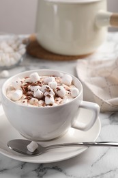 Photo of Cup of aromatic hot chocolate with marshmallows and cocoa powder served on white marble table, closeup