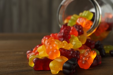 Delicious gummy bear candies on wooden table, closeup