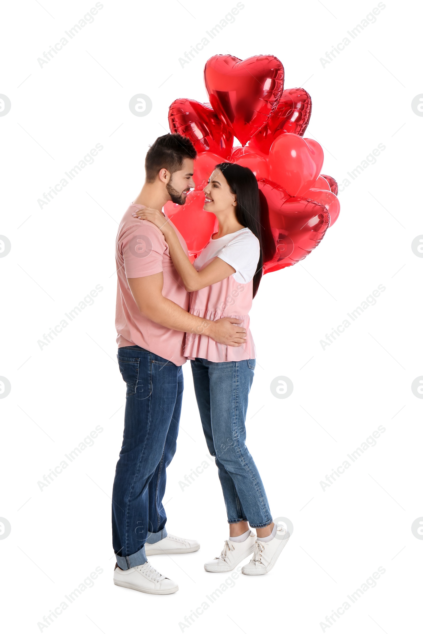 Photo of Happy young couple with heart shaped balloons isolated on white. Valentine's day celebration