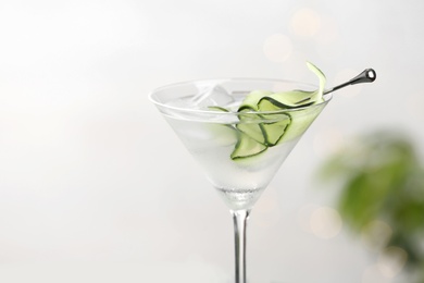 Glass of tasty cucumber martini against light background, closeup