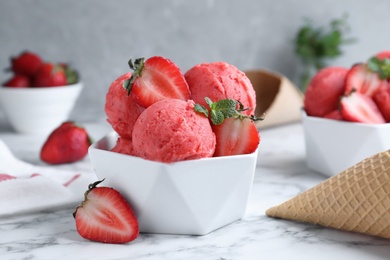 Photo of Yummy strawberry ice cream on white marble table