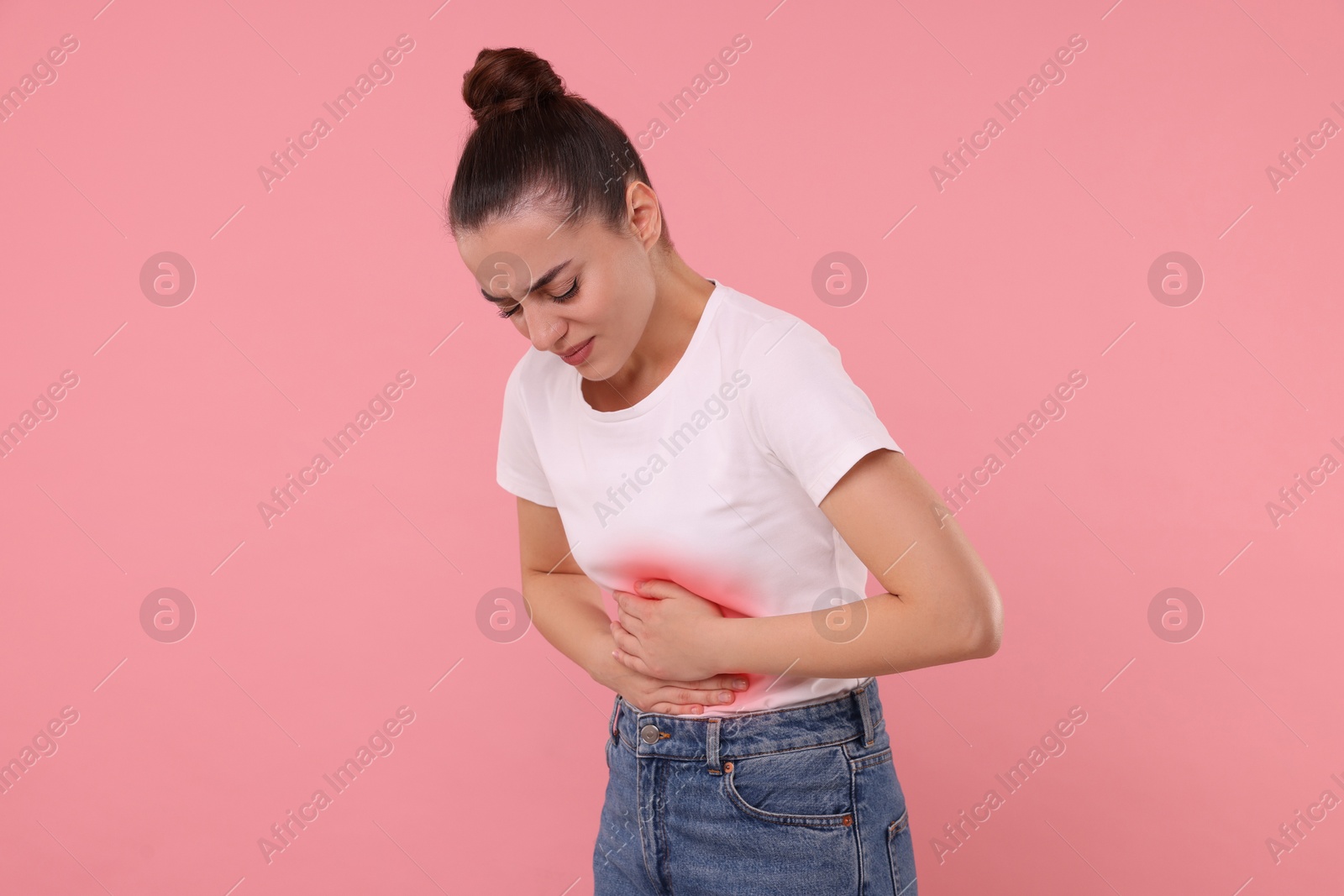 Image of Woman suffering from abdominal pain on pink background