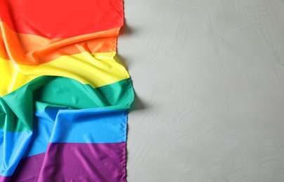 Photo of Rainbow gay flag on grey background, top view with space for text. LGBT concept