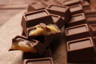 Tasty chocolate bars on wooden board, closeup