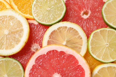 Different sliced citrus fruits as background, top view