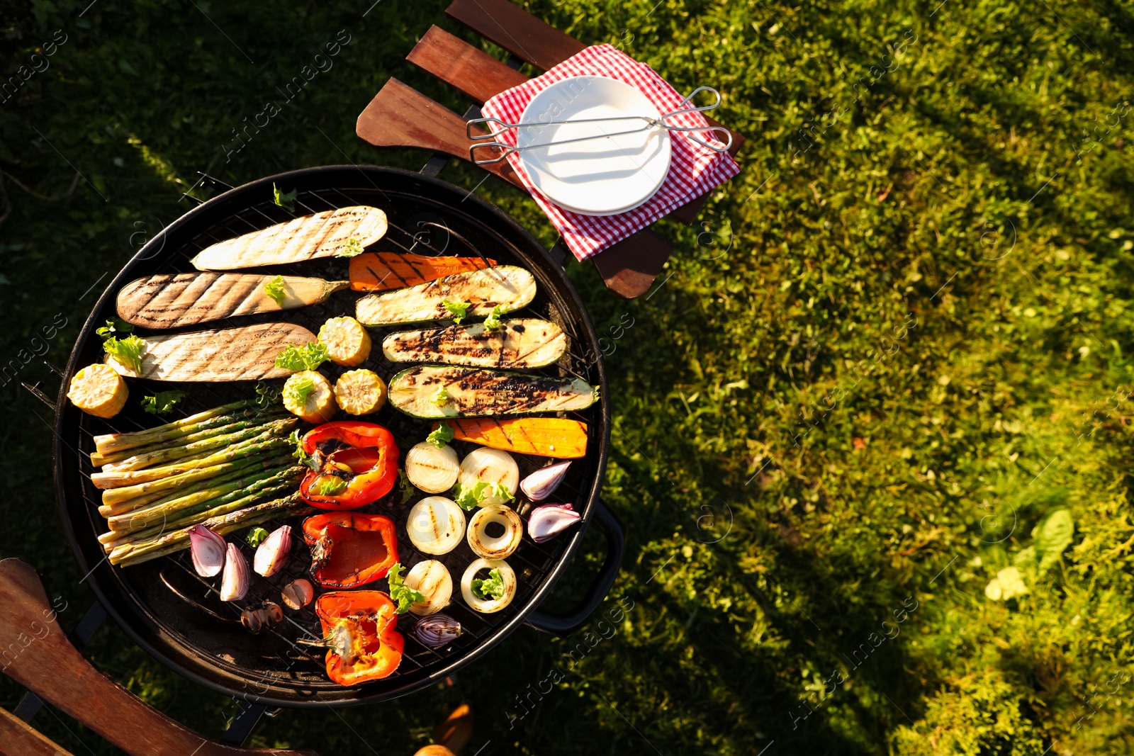 Photo of Delicious grilled vegetables on barbecue grill outdoors, top view. Space for text