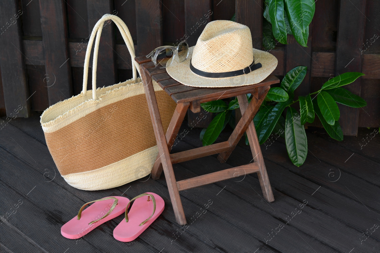 Photo of Different stylish beach accessories near wooden fence