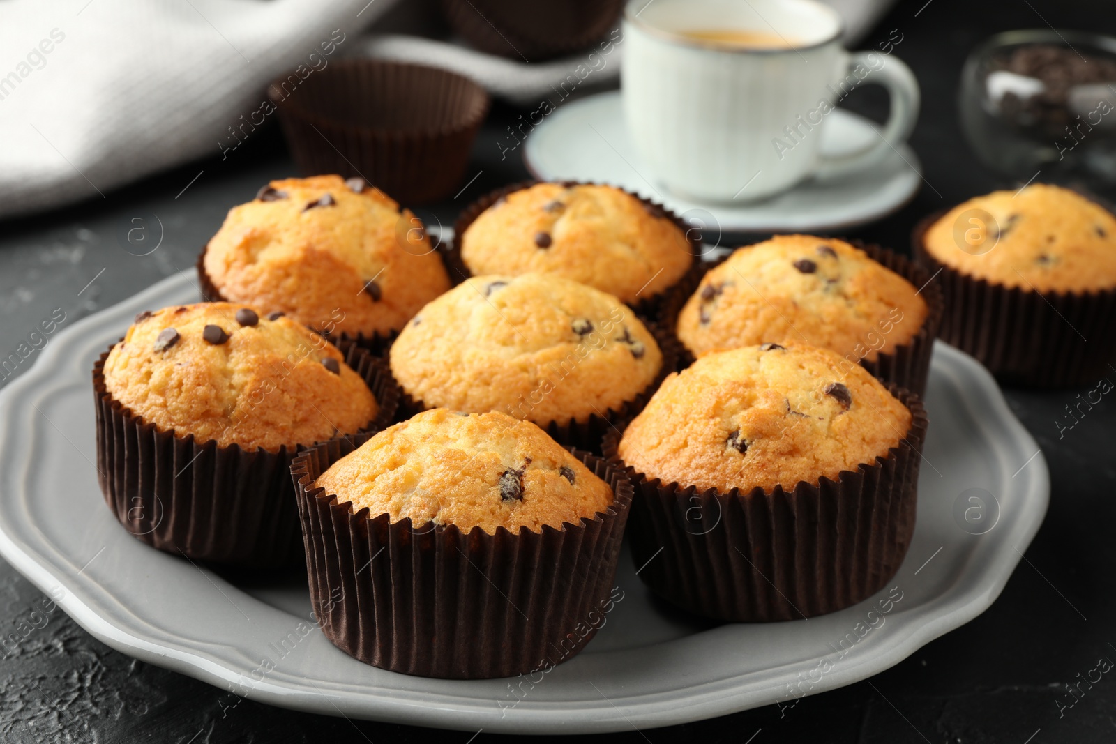 Photo of Delicious freshly baked muffins with chocolate chips on table, closeup