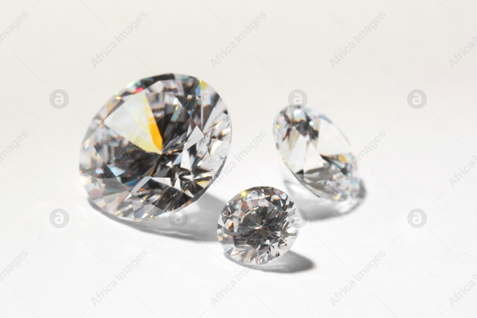 Photo of Beautiful shiny diamonds on white background, closeup