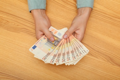 Photo of Man with Euro banknotes at table, top view
