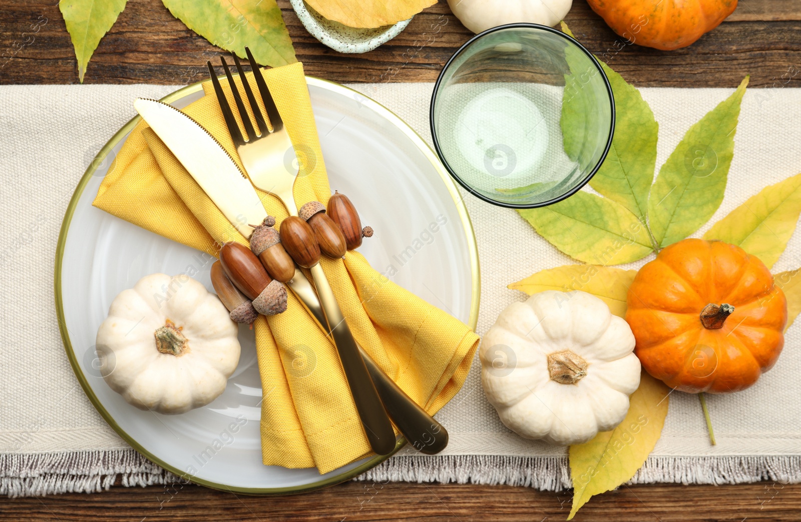 Photo of Seasonal table setting with pumpkins and other autumn decor on wooden background, flat lay