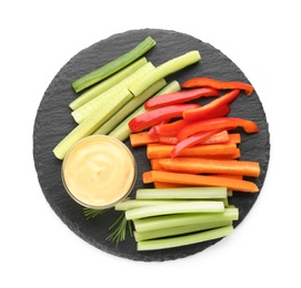 Photo of Slate plate with dip sauce, celery and other vegetable sticks isolated on white, top view