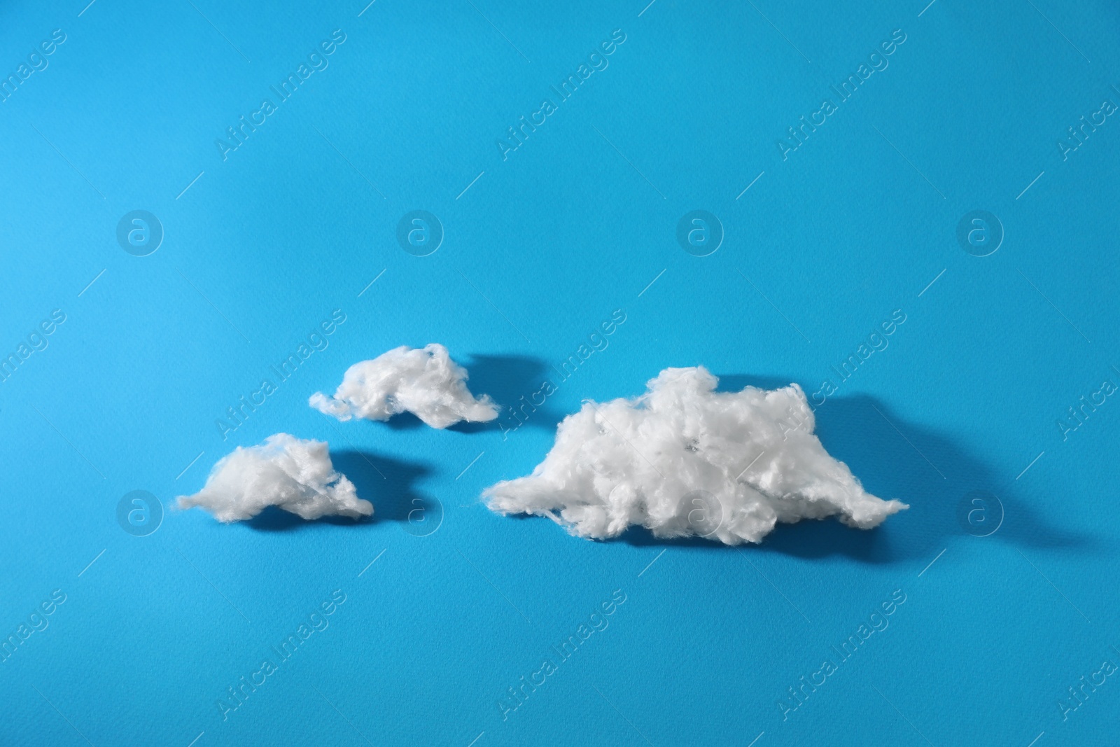 Photo of Clouds made of cotton on blue background. Space for text