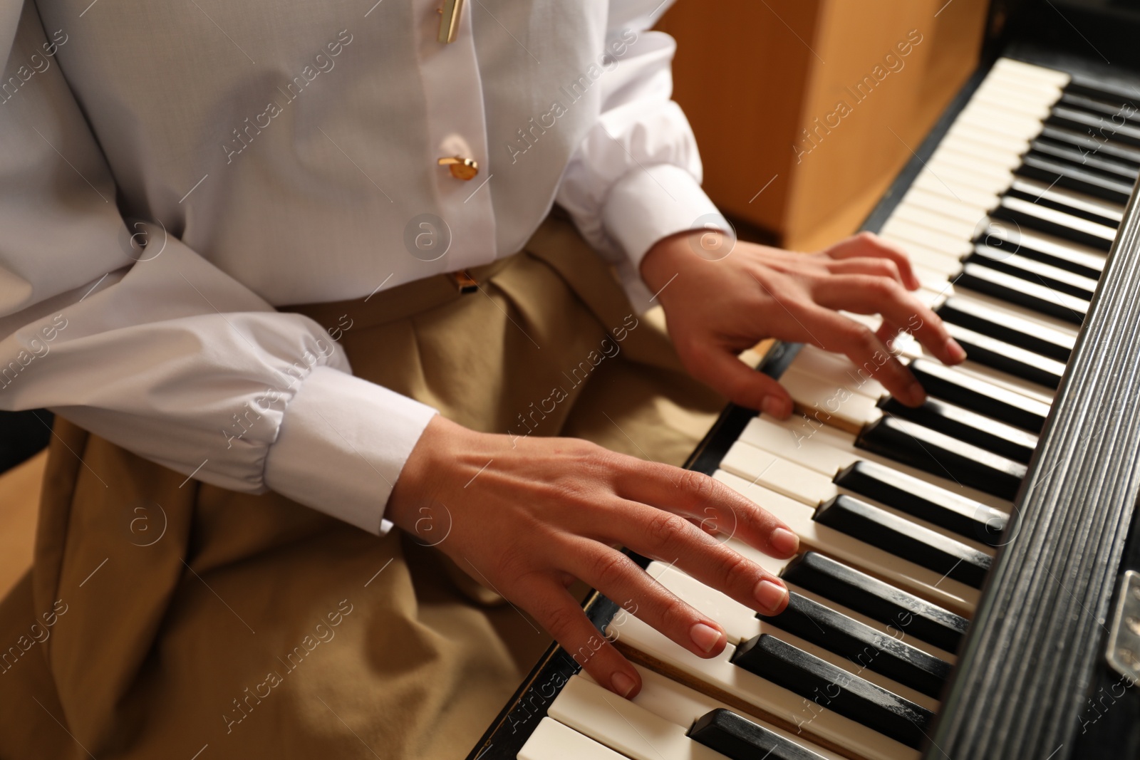 Photo of Young woman playing piano, closeup. Music lesson