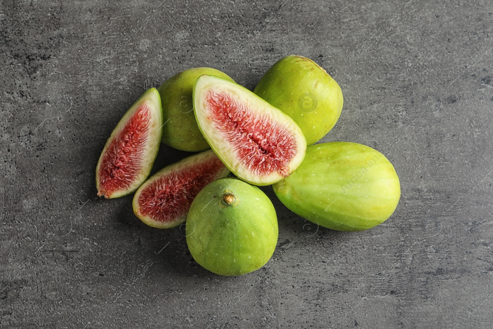 Photo of Fresh ripe figs on gray background, top view. Tropical fruit