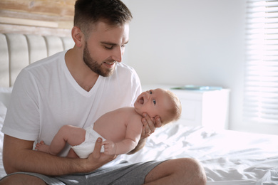 Photo of Father with his newborn son at home