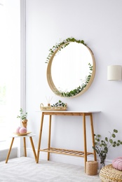 Photo of Interior of modern room with round mirror on white wall
