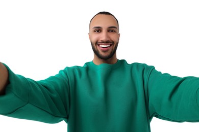 Smiling young man taking selfie on white background