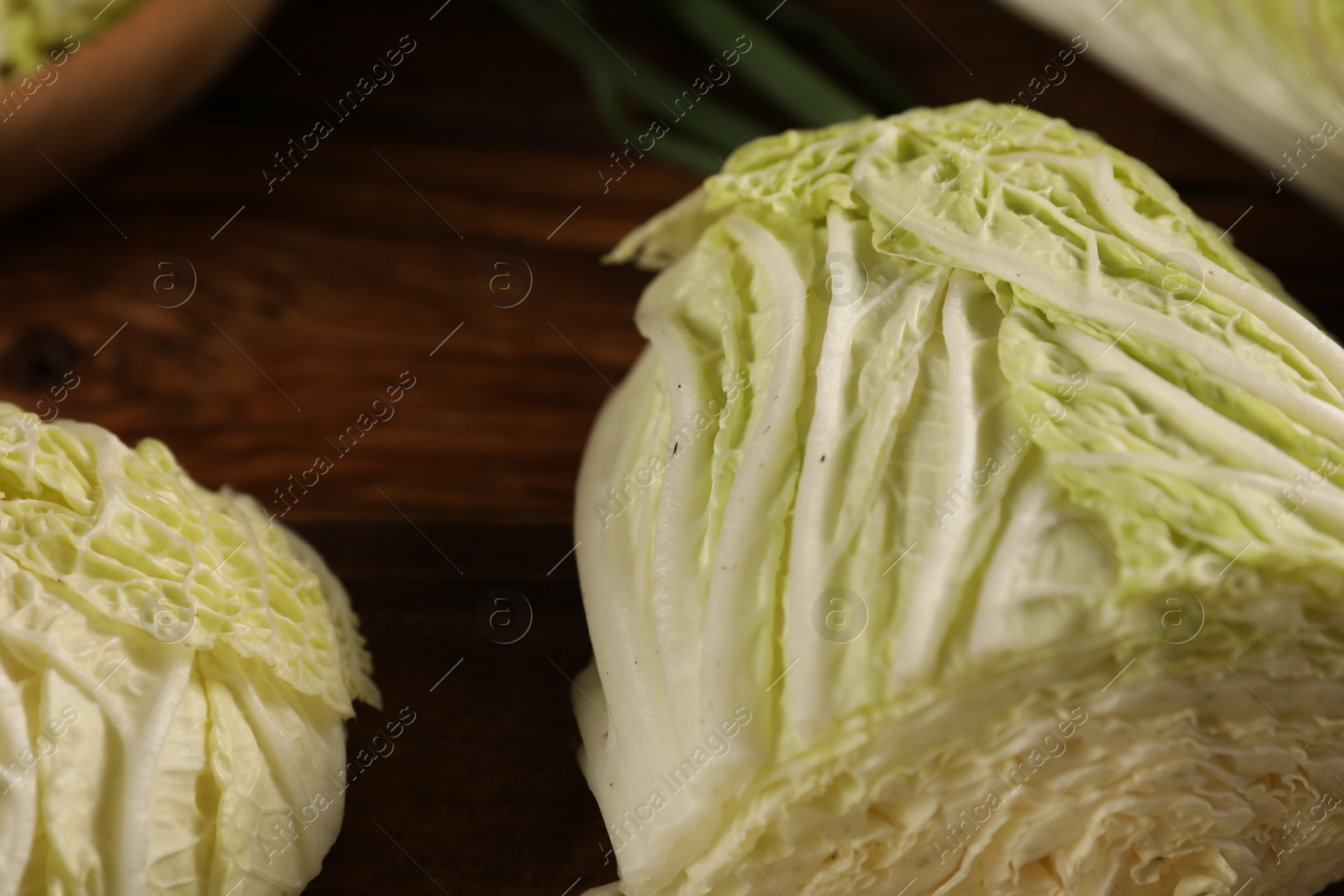 Photo of Cut fresh Chinese cabbage on wooden table, closeup