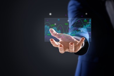 Image of Stock exchange. Businessman showing virtual icon with data against dark background, closeup