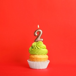 Birthday cupcake with number two candle on red background