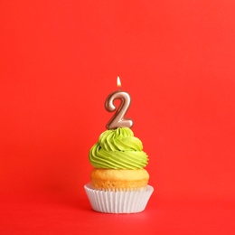 Photo of Birthday cupcake with number two candle on red background