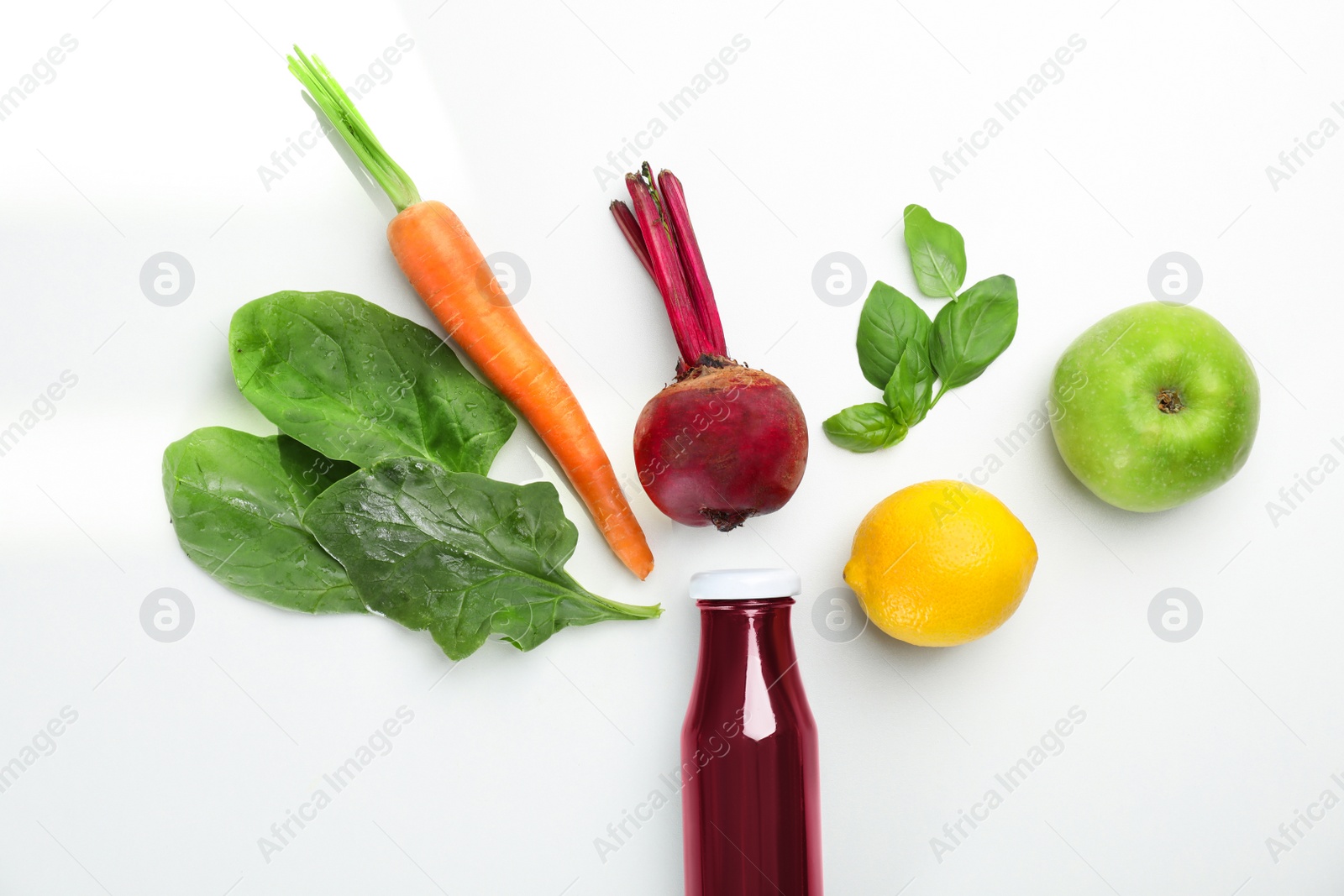 Photo of Glass bottle of fresh juice and ingredients on white background, top view