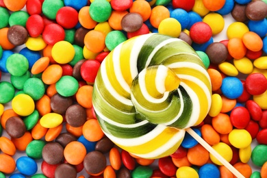 Photo of Lollipop and colorful candies as background, top view