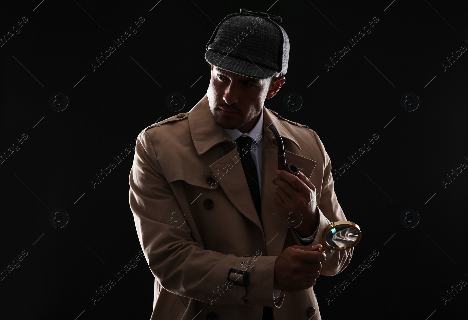 Photo of Old fashioned detective with smoking pipe and magnifying glass on dark background