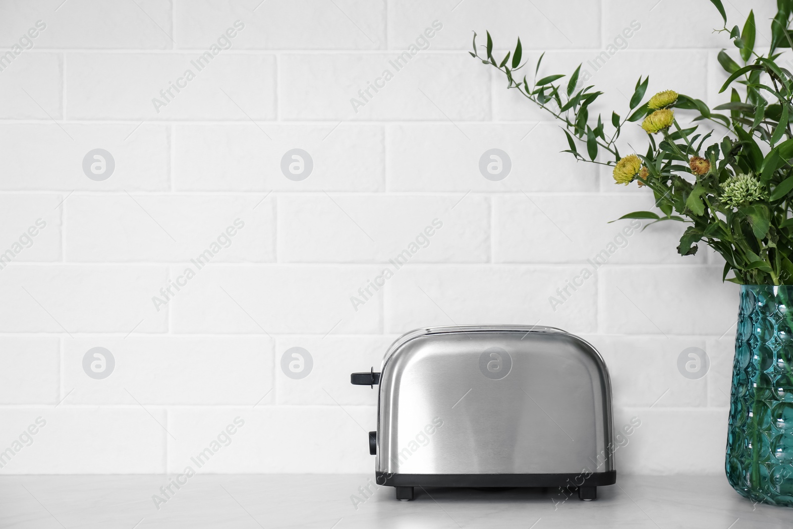 Photo of Modern stainless steel toaster on countertop in kitchen. Space for text