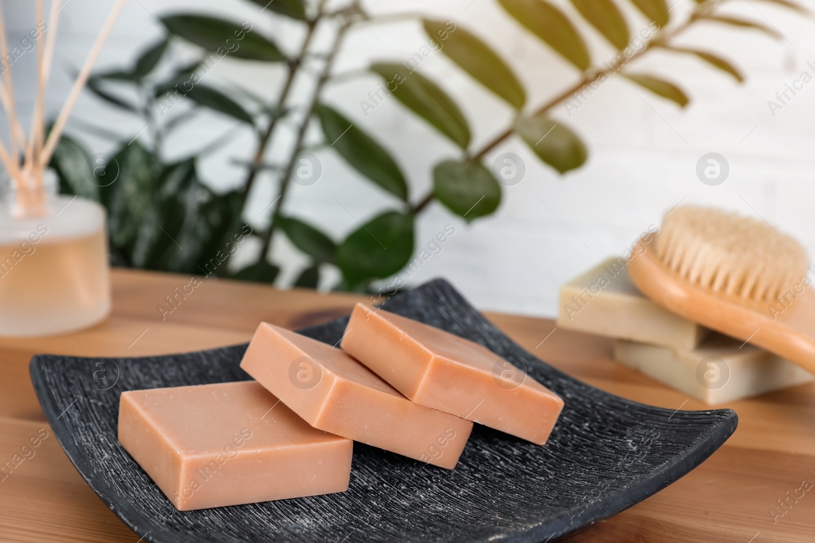 Photo of Plate with handmade soap bars on table