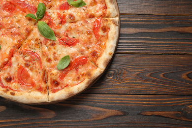 Photo of Delicious pizza Margherita on wooden table, top view. Space for text