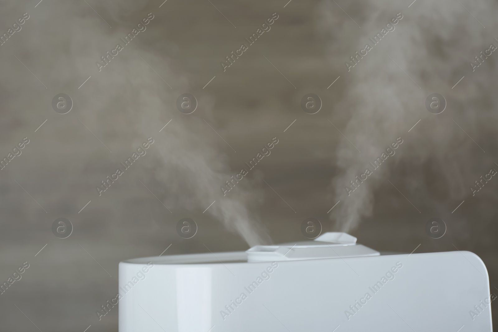 Photo of Modern air humidifier on wooden background, closeup. Space for text