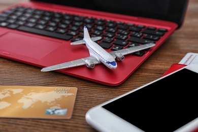 Composition with airplane model and laptop on wooden table. Travel agency concept