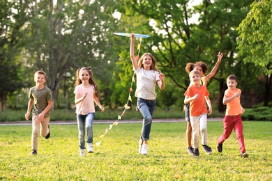 Photo of Cute little children playing with kite outdoors on sunny day