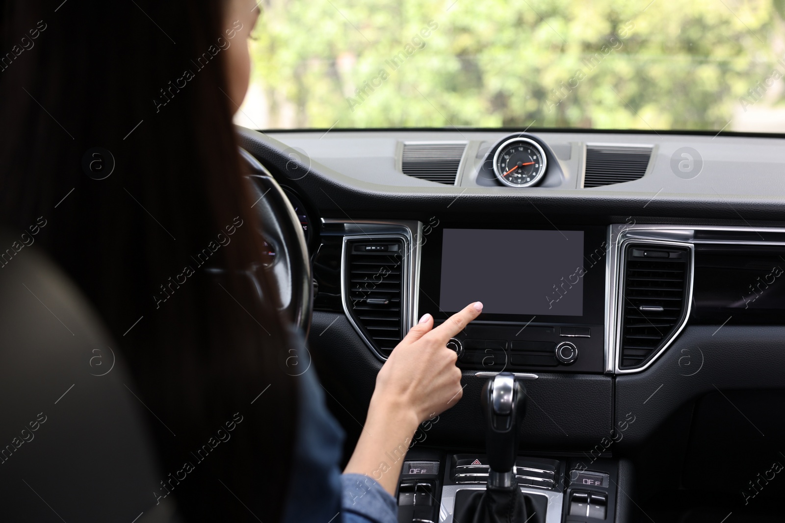 Photo of Woman using navigation system while driving her car, closeup