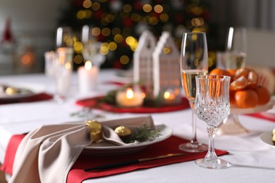 Photo of Christmas table setting with beautiful napkin, cutlery and dishware indoors
